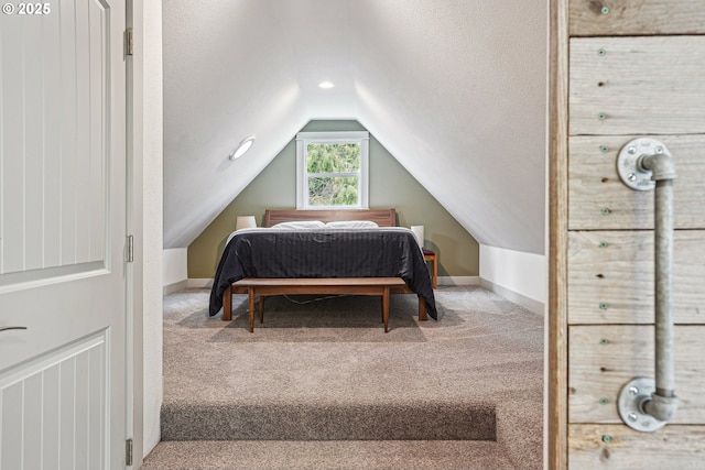 carpeted bedroom featuring lofted ceiling, a textured ceiling, and baseboards