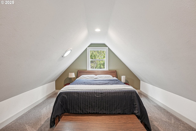 carpeted bedroom with vaulted ceiling, a textured ceiling, and baseboards