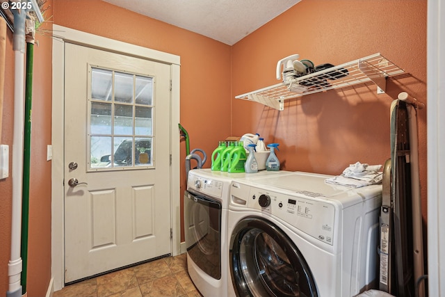 washroom featuring laundry area, washer and clothes dryer, and a textured ceiling