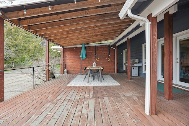 wooden terrace with outdoor dining space and area for grilling