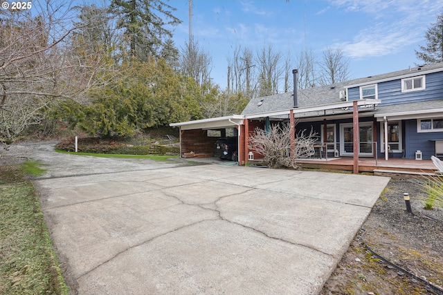 exterior space with a shingled roof and concrete driveway