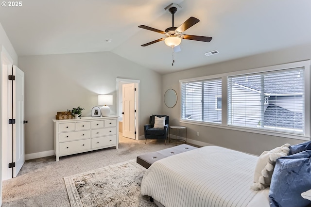 bedroom featuring vaulted ceiling, light colored carpet, ceiling fan, and ensuite bathroom