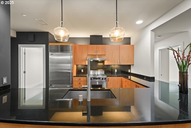 kitchen with decorative light fixtures and appliances with stainless steel finishes