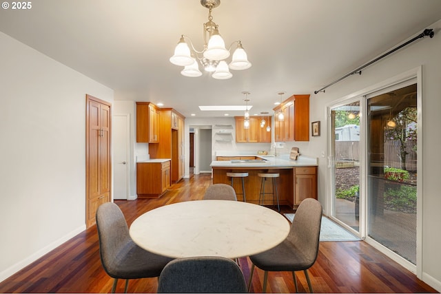 dining space with a chandelier, wood finished floors, baseboards, and recessed lighting