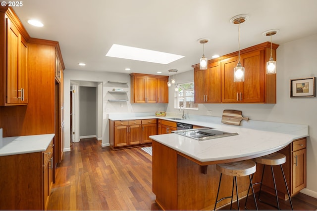 kitchen with a peninsula, a sink, a skylight, open shelves, and brown cabinetry