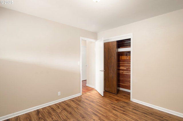 unfurnished bedroom with baseboards, a closet, and wood finished floors