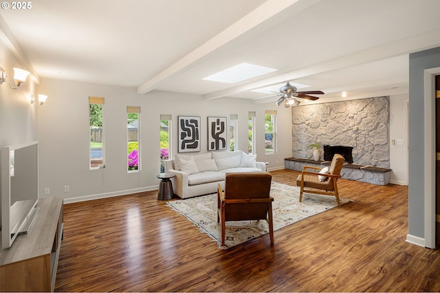 living room with plenty of natural light, baseboards, wood finished floors, and beam ceiling