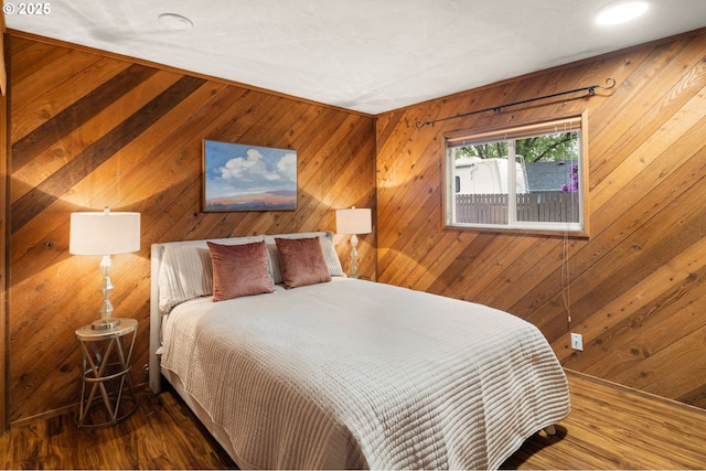 bedroom featuring wood walls and wood finished floors
