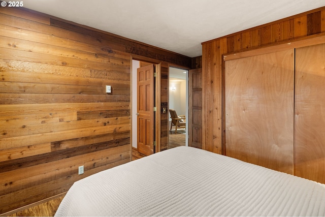 bedroom with wood walls and a closet