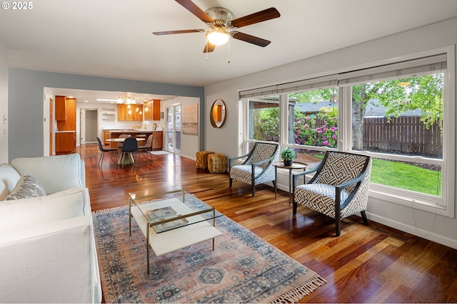 living room featuring baseboards, a chandelier, wood finished floors, and ceiling fan