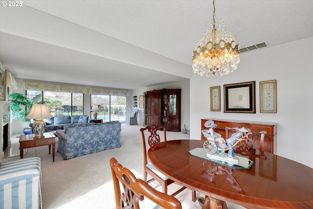 dining area with a fireplace, an inviting chandelier, carpet, and visible vents