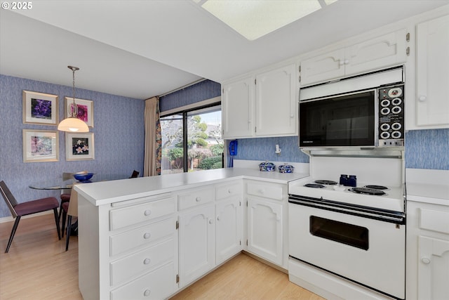 kitchen with light wood finished floors, wallpapered walls, a peninsula, electric range, and white cabinets