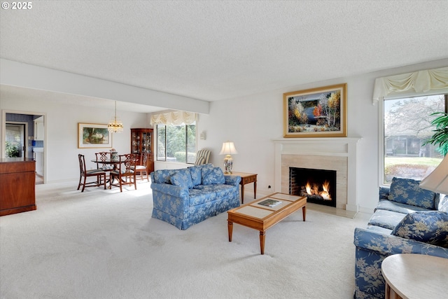 living room featuring light colored carpet, a warm lit fireplace, and a textured ceiling