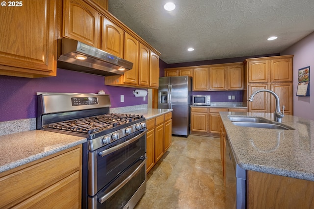 788 SE Meadows Loop, Sheridan, OR 97378 - kitchen featuring light stone countertops, stainless steel appliances, under cabinet range hood, and a sink