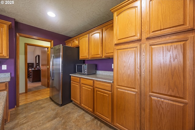 788 SE Meadows Loop, Sheridan, OR 97378 - kitchen featuring stainless steel appliances, a textured ceiling, recessed lighting, brown cabinets, and light countertops