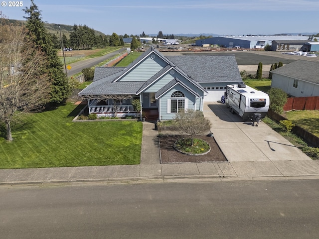 788 SE Meadows Loop, Sheridan, OR 97378 - view of front of house with a front lawn, driveway, a shingled roof, a porch, and a garage