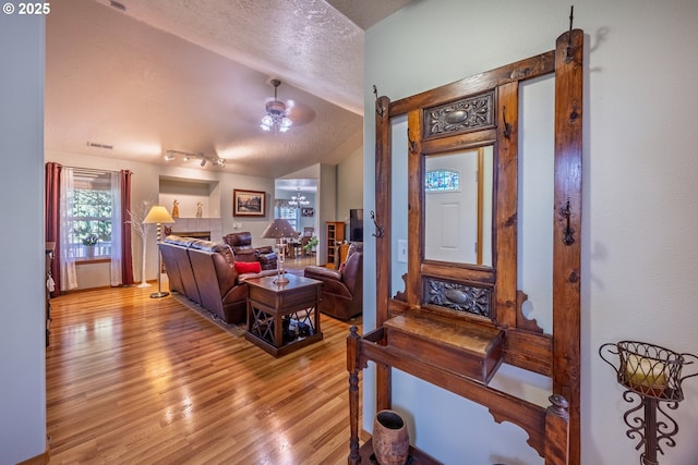 788 SE Meadows Loop, Sheridan, OR 97378 - living area with a ceiling fan, a textured ceiling, light wood-style floors, lofted ceiling, and visible vents
