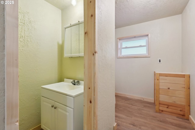 bathroom featuring hardwood / wood-style flooring, vanity, and a textured ceiling