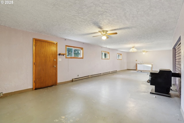 interior space featuring ceiling fan, a baseboard heating unit, and a textured ceiling