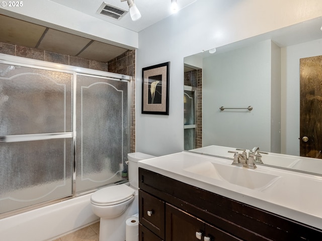 full bathroom featuring tile patterned floors, enclosed tub / shower combo, vanity, and toilet