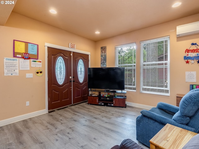 living room with hardwood / wood-style flooring and an AC wall unit