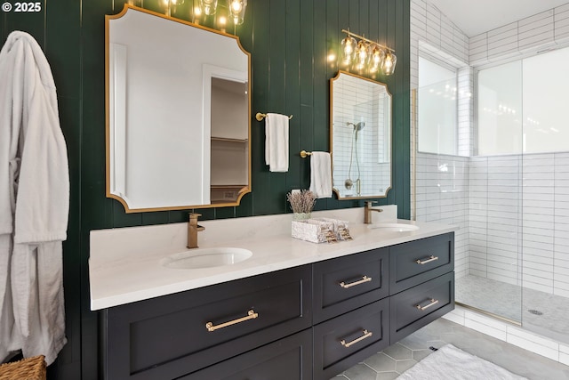 full bath featuring double vanity, a sink, and a shower stall