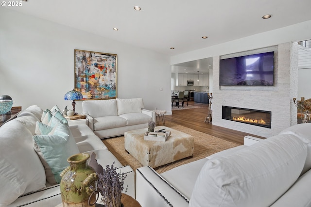 living area with recessed lighting, a fireplace, and wood finished floors