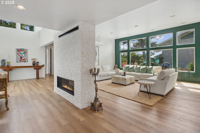 living room with recessed lighting, a barn door, a fireplace, and wood finished floors