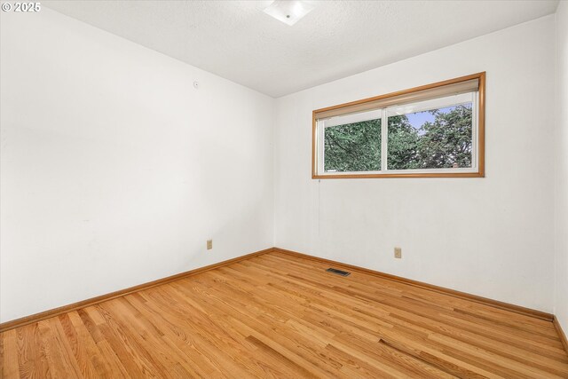 1220 NE 196th Ave, Portland, OR 97230 - unfurnished room with wood finished floors and a textured ceiling