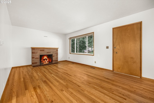 1220 NE 196th Ave, Portland, OR 97230 - unfurnished living room featuring light wood finished floors and a fireplace with flush hearth