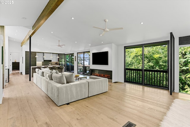 1801 NW Walmer Dr, Portland, OR 97229 - living room featuring a ceiling fan, light wood-style flooring, a glass covered fireplace, a wall of windows, and recessed lighting