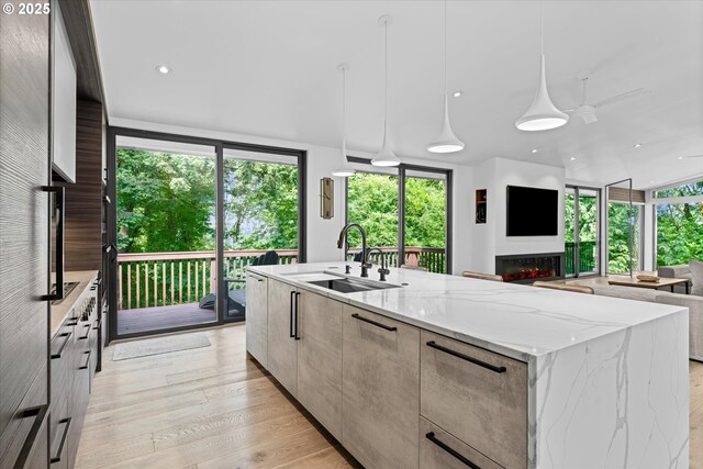 1801 NW Walmer Dr, Portland, OR 97229 - kitchen featuring modern cabinets, open floor plan, a spacious island, light stone countertops, and pendant lighting