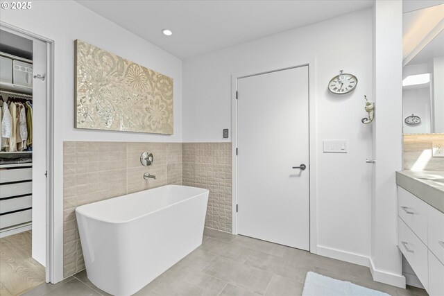1801 NW Walmer Dr, Portland, OR 97229 - bathroom featuring vanity, tile walls, a freestanding bath, a walk in closet, and tile patterned flooring
