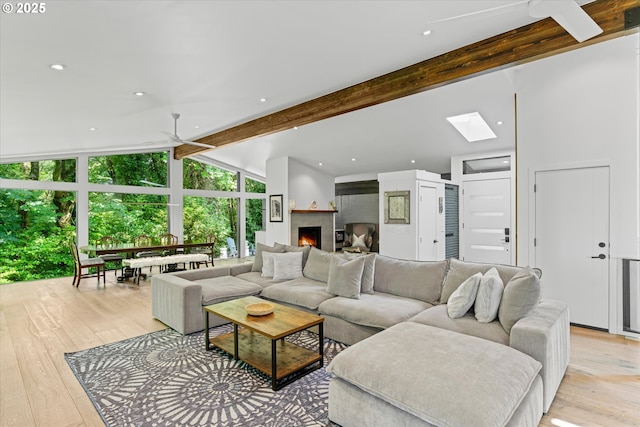 1801 NW Walmer Dr, Portland, OR 97229 - living room with light wood finished floors, ceiling fan, a warm lit fireplace, a skylight, and recessed lighting