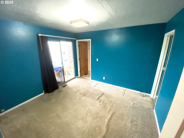 carpeted empty room with a textured ceiling