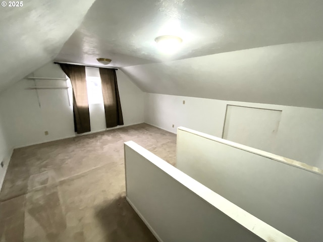 bonus room featuring lofted ceiling and light carpet