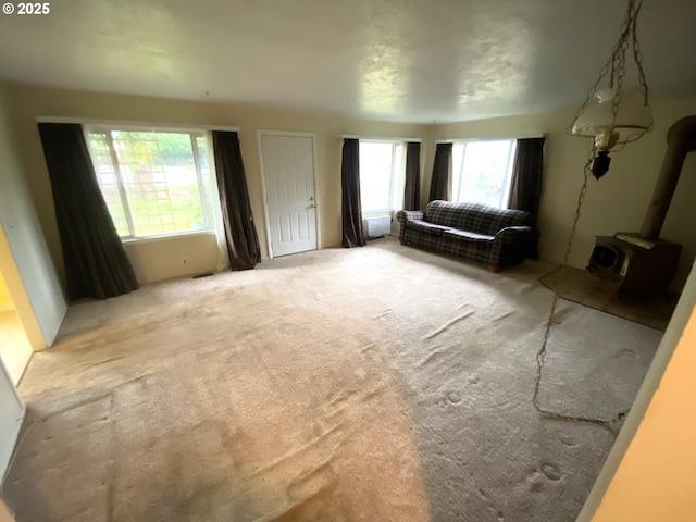 living room with a wood stove and light colored carpet