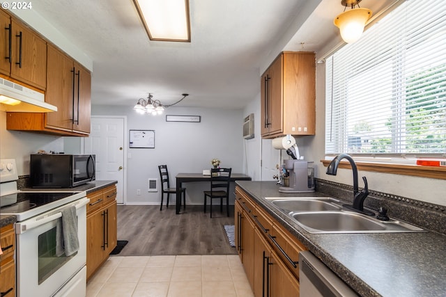 kitchen featuring white electric range oven, sink, light tile patterned floors, dishwasher, and a chandelier