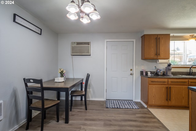 dining room featuring a chandelier, a wall unit AC, and sink