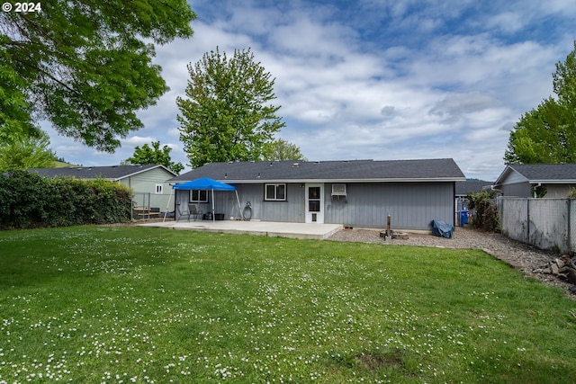 rear view of house with a patio area and a lawn