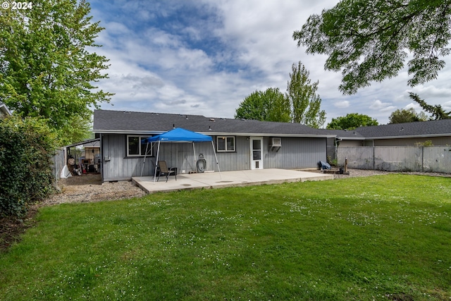 back of house with a yard and a patio