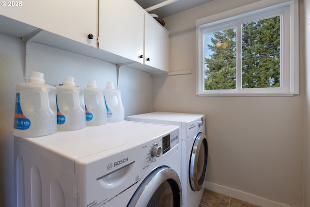 laundry room featuring independent washer and dryer, cabinets, and light tile patterned flooring