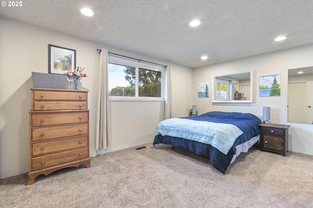 bedroom featuring carpet flooring and a textured ceiling