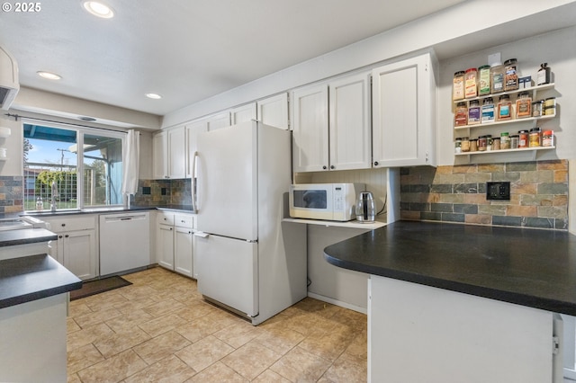 kitchen with backsplash, white cabinets, and white appliances