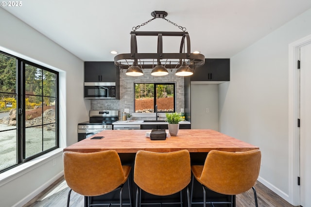 dining space featuring baseboards, dark wood-type flooring, and recessed lighting