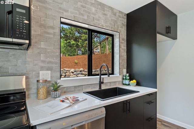 kitchen featuring black microwave, a sink, dishwasher, and light countertops