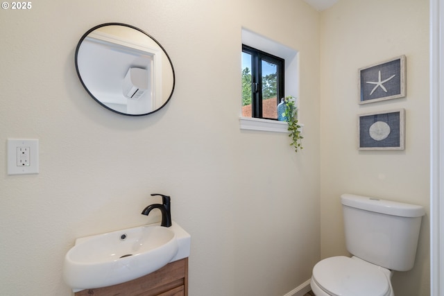 bathroom with toilet, vanity, and baseboards