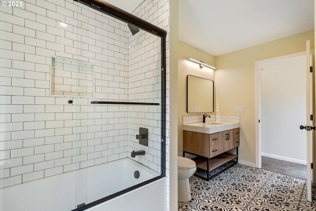 bathroom featuring bath / shower combo with glass door, toilet, vanity, and baseboards
