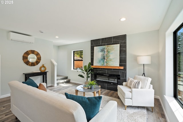 living room with a wall mounted AC, healthy amount of natural light, baseboards, and recessed lighting