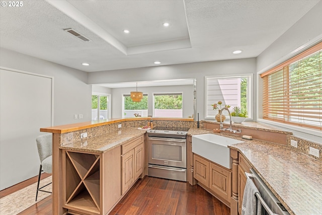 48 Eagle Crest Dr Unit 3D, Lake Oswego, OR 97035 - kitchen featuring appliances with stainless steel finishes, dark wood-style flooring, plenty of natural light, a kitchen bar, and recessed lighting